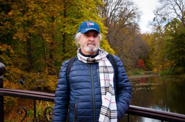 Havuzda sonbahar tarzı sakallı yaşlı bir adam. Kıdemli adam ve göl göleti. Parkta sonbahar adamı. Sonbahar sezonunda Central Park 'ta. Park 'ta son sınıf öğrencisi. Sonbahar açık havada. Sonbahar doğasında emeklilik.