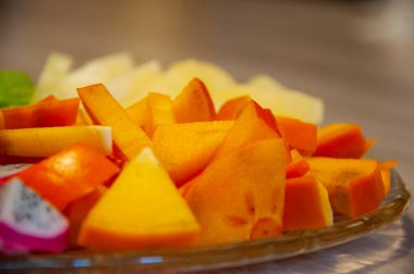 Tropik yiyecekler. Egzotik meyve. Diospyros 'un egzotik yaz meyveleri. Egzotik vitamin salatası. Tropik salata. Ada yemeği. Lüks meyve karışımı.