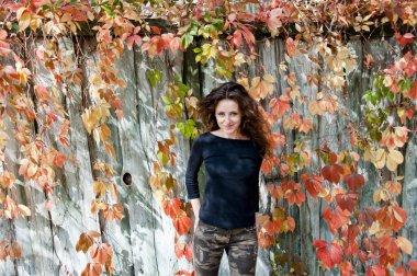 Sonbahar portresi. Sonbahar tarzı kıvırcık saçlı bir kız. Sonbahar kızı tarzı moda. Kadın saç bakımı. Açık havada kadın portresi. Sonbahar yaprakları ve genç bir kız. Sonbahar parkında milenyum kadını. Okul sezonu.