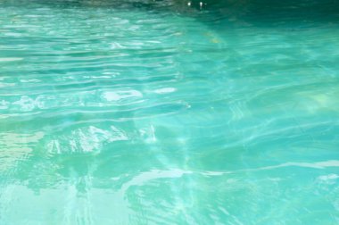 Deniz suyu yüzeyi. Okyanusun dalgalı suyu. Aquamarine okyanus doğası. Turkuaz turkuaz berrak deniz suyu. Idyllic yaz tatili. Karayip Denizi. Dalgalı yüzey. Işıldayan havuz ışıkları.