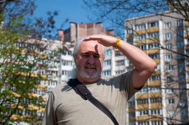 Bahar ağacı olan yaşlı bir adam sokakta. Emeklilik döneminde parkta yürümek. Tasasız emeklilik. Spring Caddesi 'nde yürüyen son sınıf öğrencisi. Bahar mevsimi açık havada. Idyllic mahalle.