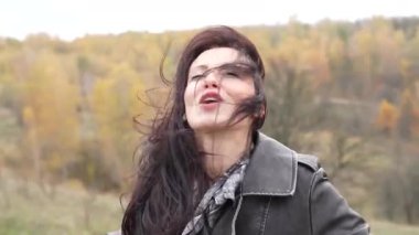 Sonbahar siperindeki kız. Gotik bir kadınla sonbahar manzarası rüzgarlı saçlara sahiptir. Şık bir kadın sonbahar manzarasında şarkı söyler. Sonbahar manzarası ve kız. New York 'taki Central Park' ta. Kuvvetli rüzgarlar.