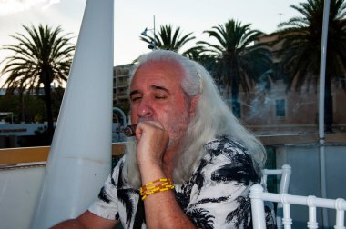 Yaz tatilinde elinde puro olan son sınıf öğrencisi. Elinde puro olan yakışıklı, olgun bir adamın portresi. Sigara içen yakışıklı bir adamın portresi. Dışarıda Küba purosu içen yakışıklı adam..