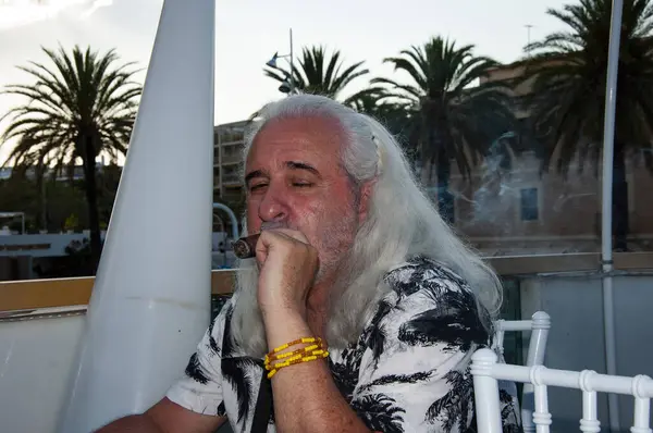 Yaz tatilinde elinde puro olan son sınıf öğrencisi. Elinde puro olan yakışıklı, olgun bir adamın portresi. Sigara içen yakışıklı bir adamın portresi. Dışarıda Küba purosu içen yakışıklı adam..