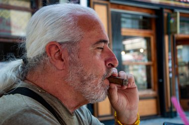 Yaz tatilinde elinde puro olan son sınıf öğrencisi. Elinde puro olan yakışıklı, olgun bir adamın portresi. Sigara içen yakışıklı bir adamın portresi. Sigara içen bir mafya babasının portresi. Mafya patronu. Boşluğu kopyala.