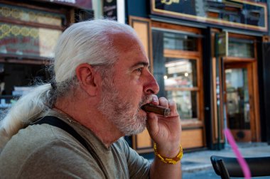 Dışarıda Küba purosu içen yakışıklı adam. Lüks emeklilik. Yaz tatilinde elinde puro olan son sınıf öğrencisi. Elinde puro olan yakışıklı, olgun bir adamın portresi. Boşluğu kopyala.