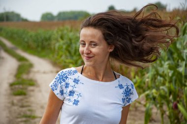 Vyshyvanka adında Ukrayna nakışı takan bir kadın. Ukrayna ulusal kıyafetleri. Kırsal kesimde Ukraynalı bir kız. Ukrayna 'nın bağımsızlık günü. Vyshyvanka Günü. 15 Mayıs. Kutsal semboller.