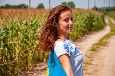 Hasatçı kız Ukrayna bayrağını tarlada tutuyor. Ukrayna bayrağı. Ulusal vatansever kız. Bağımsızlık Günü. Vatanseverlik sembolü. Vatanseverlik. Ukrayna bayrağı anma günü veya 24 Ağustos.