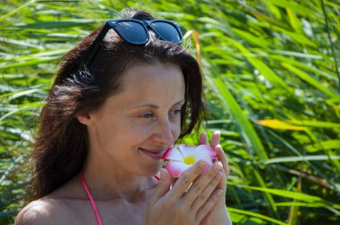 Saçında çiçek olan kadın portresi. Hawaii gezisi. Yaz tatili. Tropik doğa güzelliği. Doğa ve kadınlık. Yazın egzotik tatil. Amber çiçekli Hawaii kızı. Çiçek kokusu..