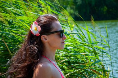 Yaz tatili. Tropik doğa güzelliği. Doğa ve kadınlık. Yazın egzotik tatil. Amber çiçekli Hawaii kızı. Saçında çiçek olan kadın portresi. Hawaii gezisi. Kadın portresi.