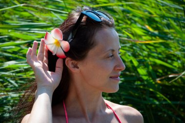 Ada hayatı. Tropik doğa güzelliği. Doğa ve kadınlık. Yazın egzotik tatil. Amber çiçekli Hawaii kızı. Saçında çiçek olan kadın portresi. Hawaii gezisi. Yaz tatili.