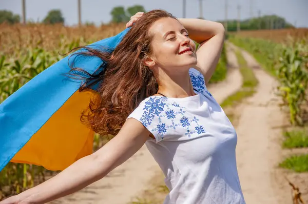 24 Ağustos. Özgür kadın vatansever. Mısır tarlasında Ukrayna bayrağı taşıyan tasasız bir kız. Ukrayna 'nın bağımsızlık günü. Özgürlük için. Ukrayna bayrağı. Bağımsızlık Günü. Ukrayna bayrağı günü. Güneşli ve rüzgarlı.