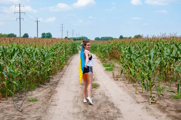 Ukrayna bayrağı anma günü veya 24 Ağustos. Tarlada Ukrayna bayrağıyla kaplanmış bir kız. Ukrayna bayrağı. Ulusal vatansever kız. Bağımsızlık Günü. Vatanseverlik. Vatansever bayram.
