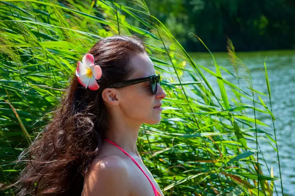 Yaz tatili. Tropik doğa güzelliği. Doğa ve kadınlık. Yazın egzotik tatil. Amber çiçekli Hawaii kızı. Saçında çiçek olan kadın portresi. Hawaii gezisi. Kadın portresi.
