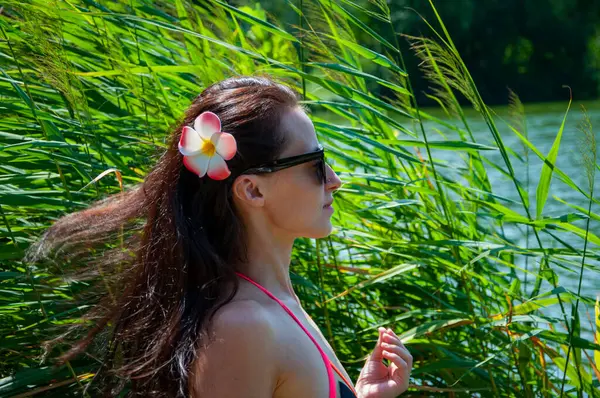 Hawaii gezisi. Yaz tatili. Tropik doğa güzelliği. Doğa ve kadınlık. Yazın egzotik tatil. Amber çiçekli Hawaii kızı. Saçında çiçek olan kadın portresi. Pankart.