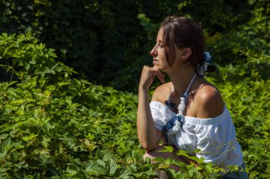 Egzotik orman. Tropik güzellik. Bitkisel ilaçlar. Rahatlama inzivası. İnci kolyeli genç İspanyol kız, yeşil beyaz. Doğa terapisi. Yeşillik ormanında oturan bir kadın. Düşünce.