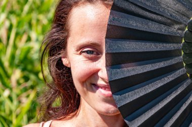 Dansçının gizli bakışları. Gizemli kadınsı gücün gözleri. Geleneksel hayranların arkasındaki gizemli gözler. Flamenko dansçısı. Kadın gözleri kırmızı siyah yelpaze. Kültürel halk zarafeti gizli bir yüz. Geyşa kız gülümsemesi.