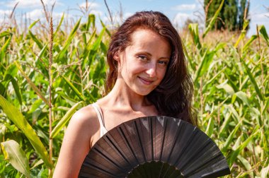 Gülümseyen yüzlü mutlu kadın siyah Flamenko yaz hayranı sıcak mısır tarlasında, geyşa modasında.