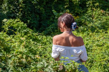 Meditasyon köşesi ve sağlık. Çekici İspanyol kız, yeşil beyaz. Doğal güzellik. Yeşillik ormanında oturan bir kadın. Organik giysiler. Kırsal yaşam tarzı. Doğa inziva hayatı. Reklam..