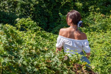 Egzotik orman. Çarpıcı tropikal güzellik. Bitkisel ilaçlar. Rahatlama inzivası. İnci kolyeli genç İspanyol kız, yeşil beyaz. Doğa terapisi. Yeşillik ormanında oturan bir kadın. Pankart.