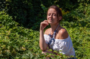 Çarpıcı tropikal güzellik. Yalnızlık ve özgürlük. Rahatlama geri çekilme yaşam tarzı. İspanyol kız, yeşil beyaz. Doğa kaçışı. Yeşillik ormanında oturan bir kadın. Boho yaz modası. Reklam..