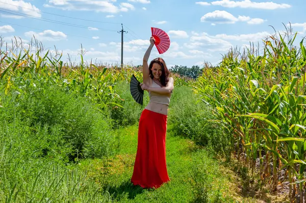 Flamenko dansçısı. Tarlada dans eden kırmızı etekli, gülümseyen kadın. Halk kültürü. Geleneksel dans flamenkosu. Sanatsal yaşam tarzı. Küresel turizm. Kadınsal özgürlük. Folklorik kız seyahati.