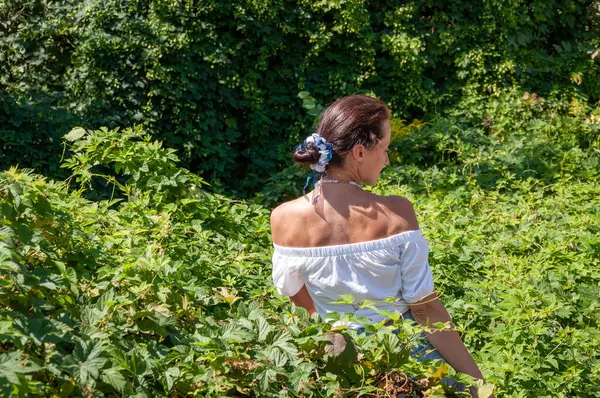 Doğa inziva hayatı. Meditasyon köşesi ve sağlık. Çekici İspanyol kız, yeşil beyaz. Doğal güzellik. Yeşillik ormanında oturan bir kadın. Organik giysiler. Kozmetik üretimi.