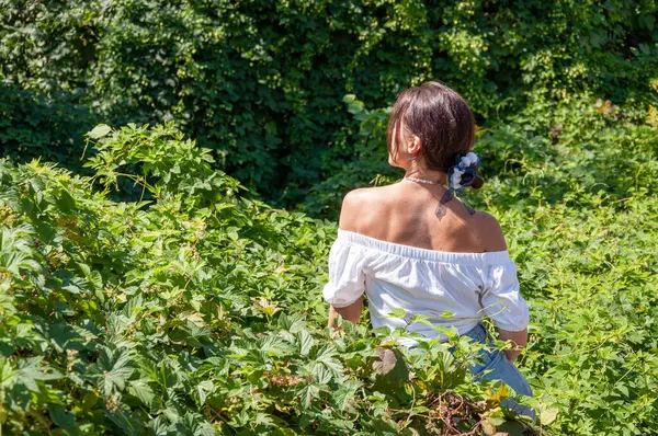 Çarpıcı tropikal güzellik. Bitkisel ilaçlar. Rahatlama inzivası. İnci kolyeli genç İspanyol kız, yeşil beyaz. Doğa terapisi. Yeşillik ormanında oturan bir kadın. Egzotik orman. Reklam..