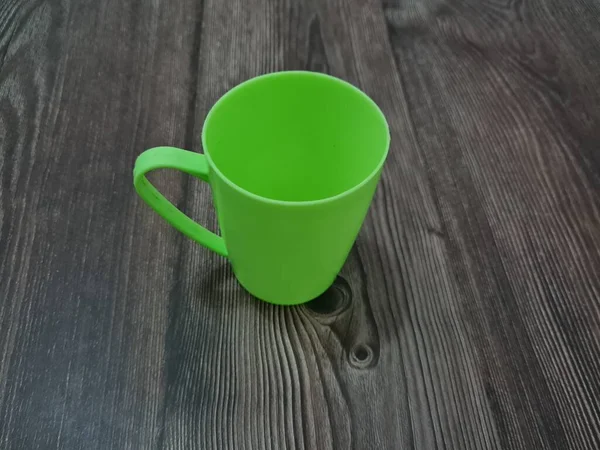 Een Glas Van Kunststof Met Een Groen Handvat — Stockfoto