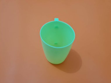 Yeşil saplı plastikten yapılmış bir bardak.