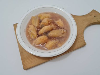 İçinde olgun muz dilimleri ve hindistan cevizi sütü sosu olan tatlı komposto.