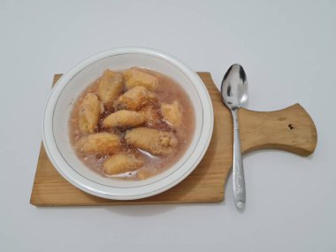 İçinde olgun muz dilimleri ve hindistan cevizi sütü sosu olan tatlı komposto.