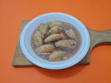 İçinde olgun muz dilimleri ve hindistan cevizi sütü sosu olan tatlı komposto.