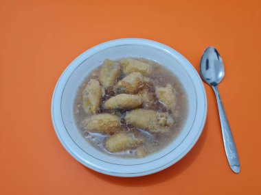 İçinde olgun muz dilimleri ve hindistan cevizi sütü sosu olan tatlı komposto.