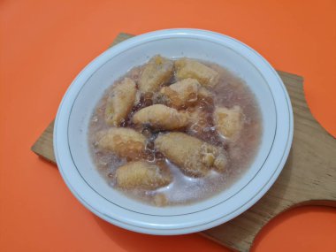 İçinde olgun muz dilimleri ve hindistan cevizi sütü sosu olan tatlı komposto.