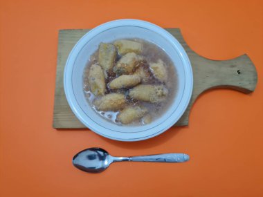 İçinde olgun muz dilimleri ve hindistan cevizi sütü sosu olan tatlı komposto.