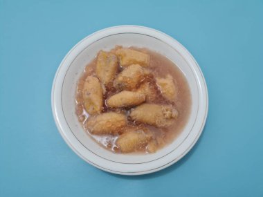 İçinde olgun muz dilimleri ve hindistan cevizi sütü sosu olan tatlı komposto.