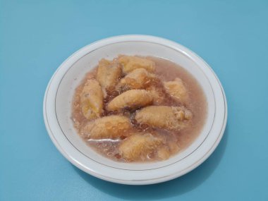 İçinde olgun muz dilimleri ve hindistan cevizi sütü sosu olan tatlı komposto.