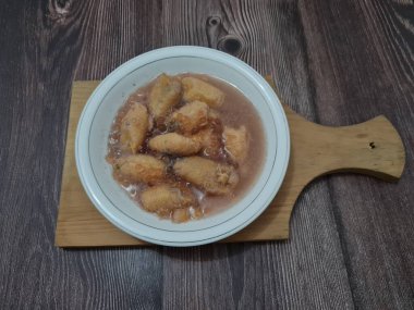 İçinde olgun muz dilimleri ve hindistan cevizi sütü sosu olan tatlı komposto.