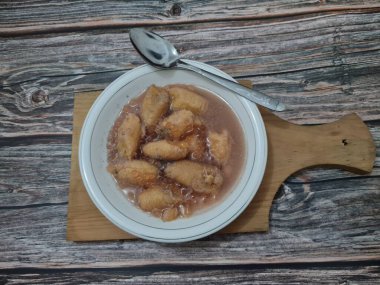 İçinde olgun muz dilimleri ve hindistan cevizi sütü sosu olan tatlı komposto.