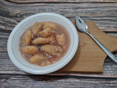 İçinde olgun muz dilimleri ve hindistan cevizi sütü sosu olan tatlı komposto.