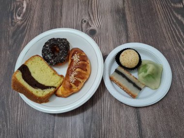 Sünger ekmeği, reçelli ekmek, çikolatalı çörek, Wingko, mendut atıştırmalıkları ve onde onde 'den oluşan bir pazar atıştırmalığı koleksiyonu.