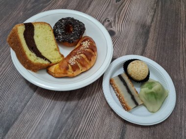 Sünger ekmeği, reçelli ekmek, çikolatalı çörek, Wingko, mendut atıştırmalıkları ve onde onde 'den oluşan bir pazar atıştırmalığı koleksiyonu.