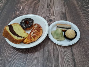 Sünger ekmeği, reçelli ekmek, çikolatalı çörek, Wingko, mendut atıştırmalıkları ve onde onde 'den oluşan bir pazar atıştırmalığı koleksiyonu.