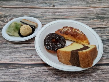 Sünger ekmeği, reçelli ekmek, çikolatalı çörek, Wingko, mendut atıştırmalıkları ve onde onde 'den oluşan bir pazar atıştırmalığı koleksiyonu.