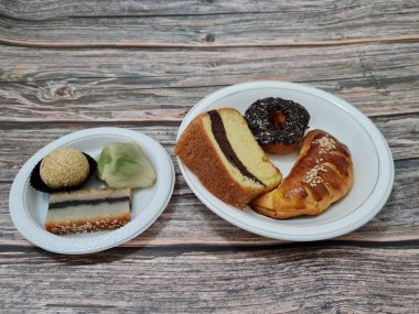 Sünger ekmeği, reçelli ekmek, çikolatalı çörek, Wingko, mendut atıştırmalıkları ve onde onde 'den oluşan bir pazar atıştırmalığı koleksiyonu.