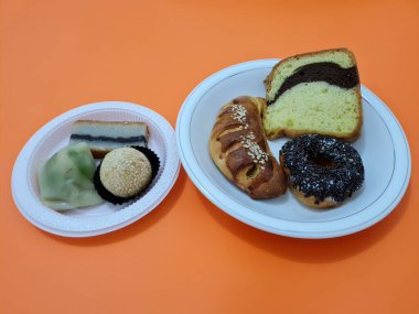 Sünger ekmeği, reçelli ekmek, çikolatalı çörek, Wingko, mendut atıştırmalıkları ve onde onde 'den oluşan bir pazar atıştırmalığı koleksiyonu.