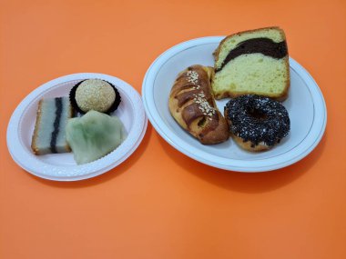 Sünger ekmeği, reçelli ekmek, çikolatalı çörek, Wingko, mendut atıştırmalıkları ve onde onde 'den oluşan bir pazar atıştırmalığı koleksiyonu.