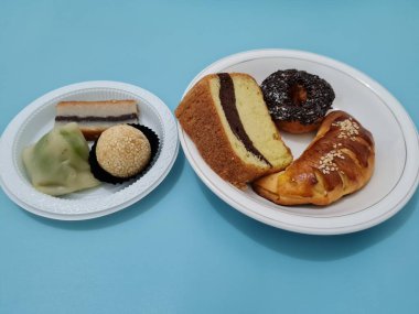 Sünger ekmeği, reçelli ekmek, çikolatalı çörek, Wingko, mendut atıştırmalıkları ve onde onde 'den oluşan bir pazar atıştırmalığı koleksiyonu.