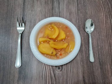 Olgun meyveler ve küçük tatlı toplarla dolu tatlı komposto.